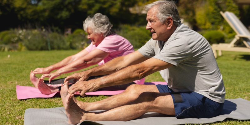 senior-caucasian-couple-practicing-yoga-stretching-sunny-garden-retirement-retreat-active-senior-lifestyle-concept (1)-min