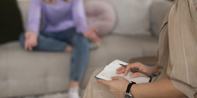 side-view-young-girl-talking-therapist (2)-min